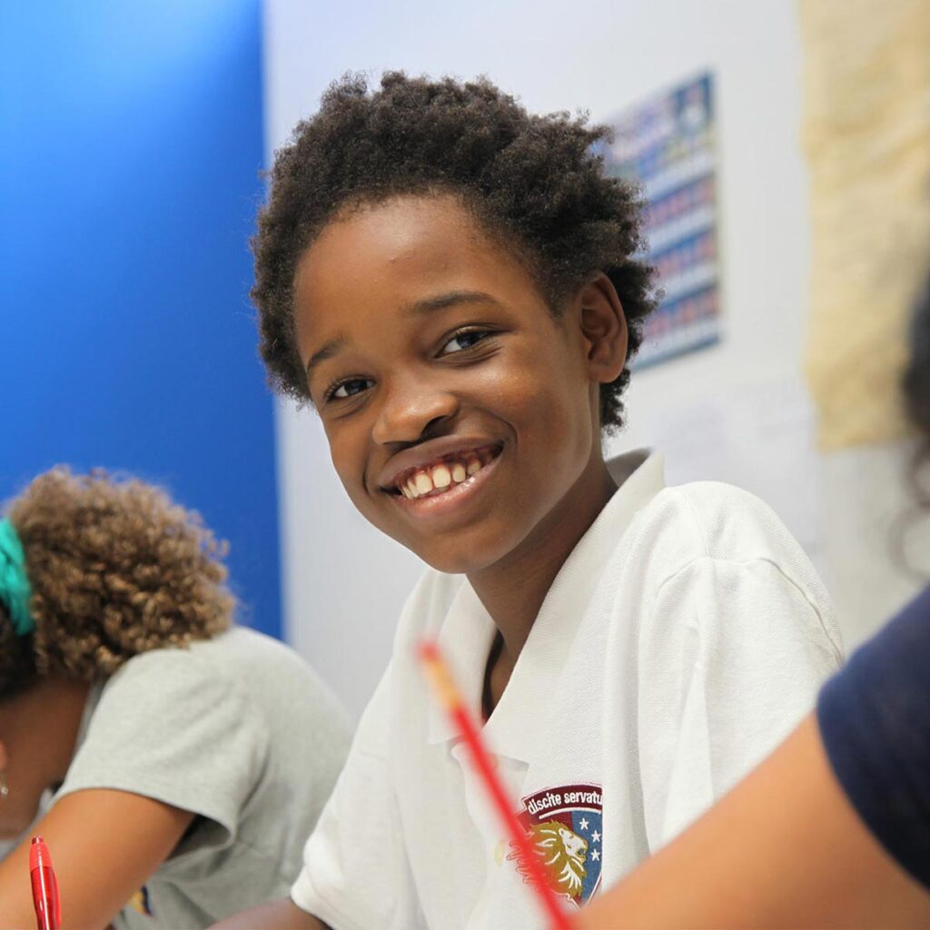 A young student looks up and smiles in class at Latin's Cooper Campus.